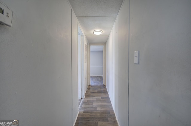 hallway featuring a textured ceiling and dark wood-type flooring