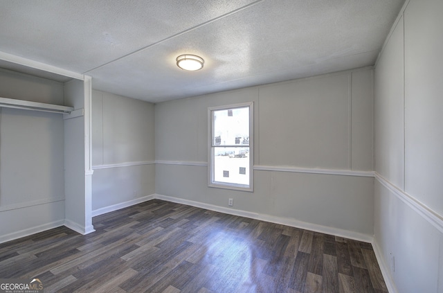 unfurnished bedroom featuring a textured ceiling, dark hardwood / wood-style floors, and a closet