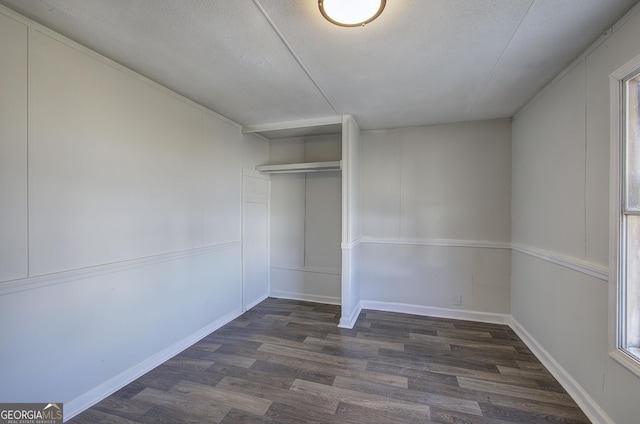 unfurnished bedroom featuring a textured ceiling, a closet, and dark hardwood / wood-style floors