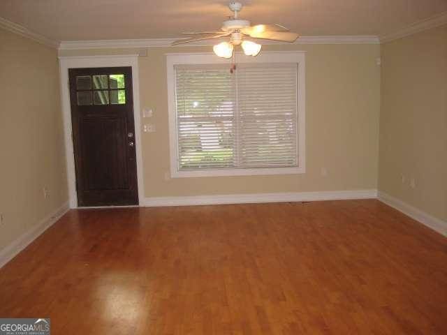 foyer entrance featuring ceiling fan, wood-type flooring, and ornamental molding