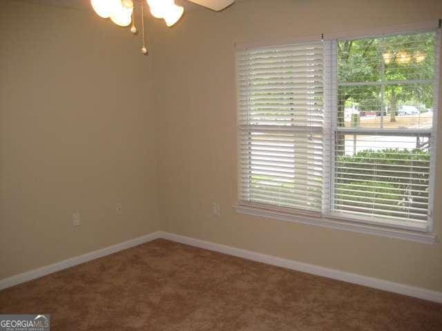 carpeted empty room featuring ceiling fan