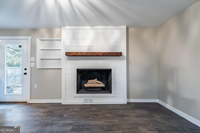 unfurnished living room featuring a fireplace and dark hardwood / wood-style floors