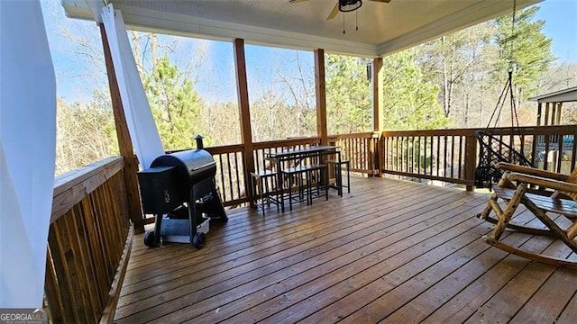 deck featuring ceiling fan and a grill