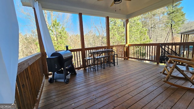 wooden terrace with ceiling fan and a grill