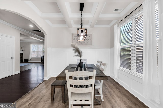 dining area with beamed ceiling, dark wood-type flooring, a healthy amount of sunlight, and coffered ceiling