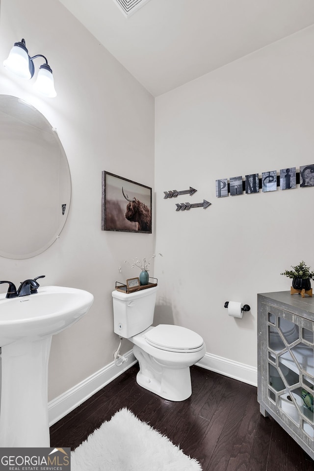 bathroom with hardwood / wood-style floors, toilet, and sink