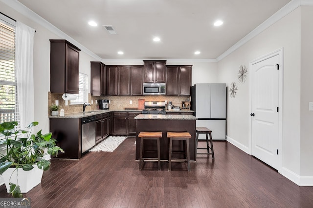 kitchen featuring dark brown cabinets, a center island, and stainless steel appliances