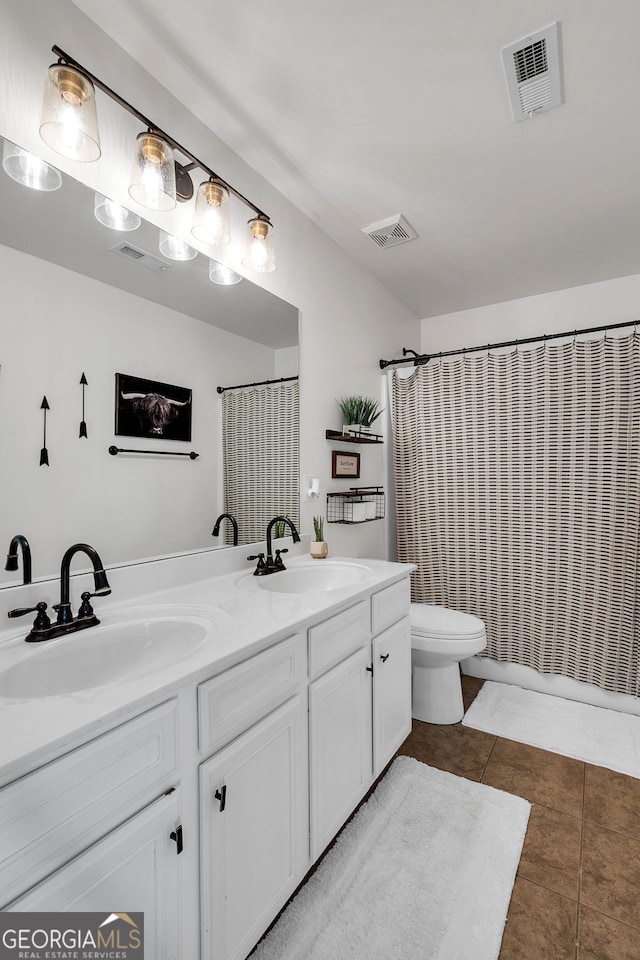 bathroom featuring tile patterned flooring, vanity, toilet, and curtained shower