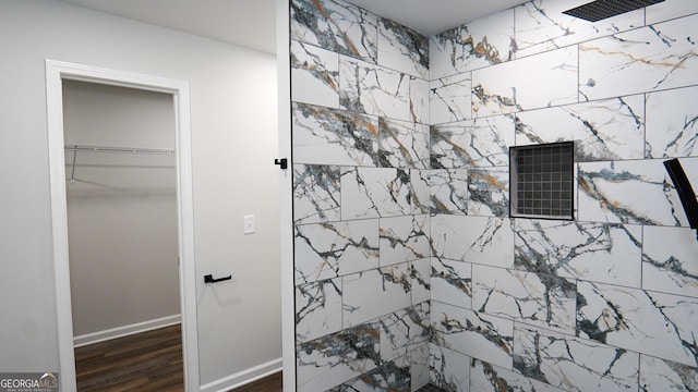 bathroom with hardwood / wood-style floors and a tile shower