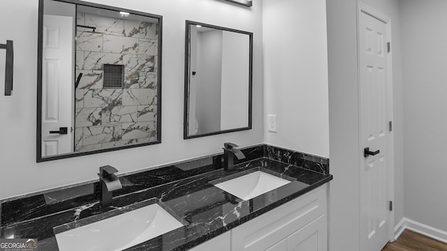 bathroom with a tile shower, vanity, and hardwood / wood-style flooring