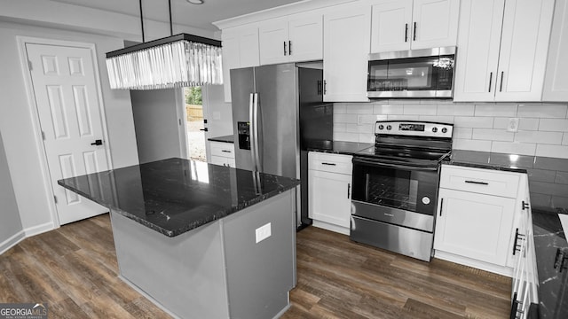 kitchen with backsplash, white cabinets, a kitchen island, and stainless steel appliances