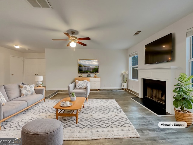 living room with ceiling fan and dark hardwood / wood-style flooring