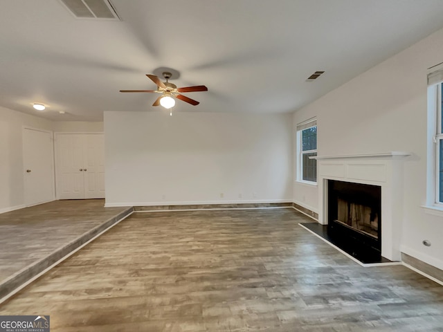 unfurnished living room featuring hardwood / wood-style floors and ceiling fan