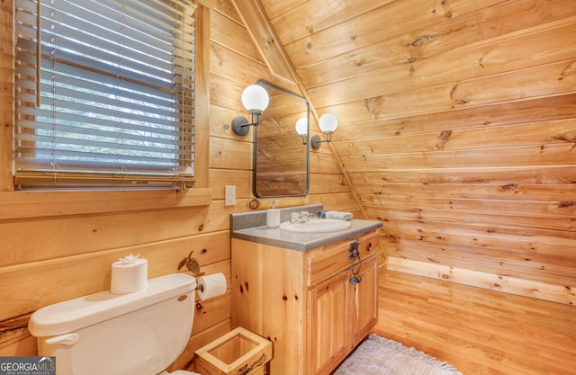 bathroom with wooden ceiling, vaulted ceiling, toilet, wooden walls, and vanity