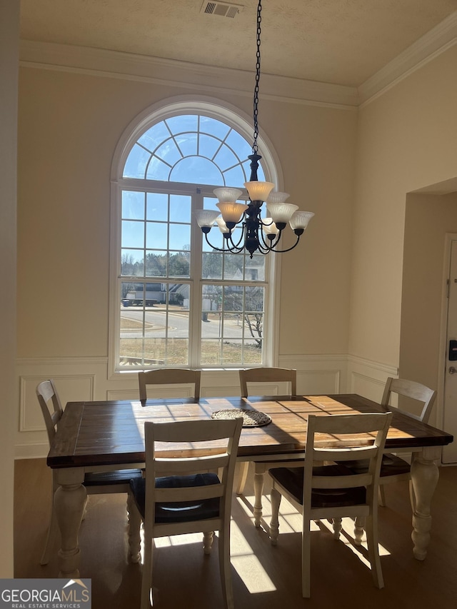 dining room with a chandelier and crown molding