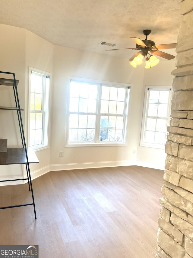 unfurnished living room featuring ceiling fan and hardwood / wood-style flooring