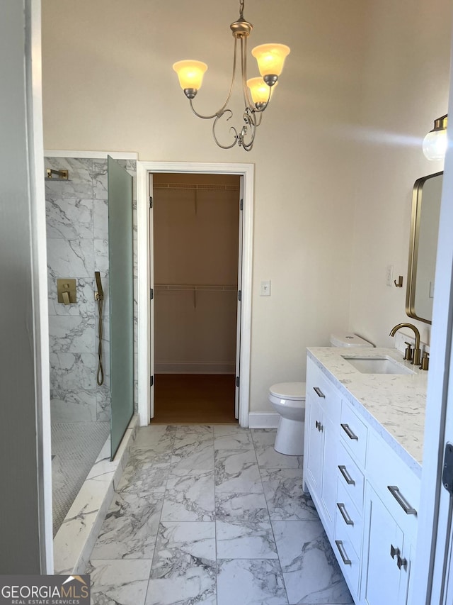 bathroom with vanity, toilet, tiled shower, and a chandelier