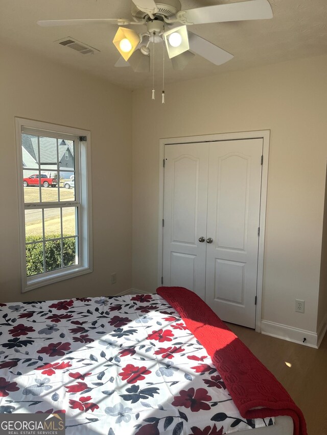 unfurnished bedroom featuring a textured ceiling, ceiling fan, a closet, and dark hardwood / wood-style floors