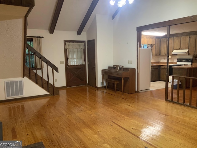 foyer entrance with vaulted ceiling with beams and light hardwood / wood-style flooring