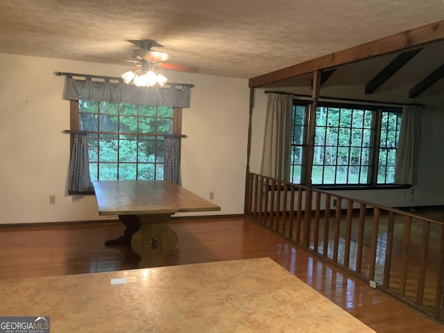 unfurnished dining area with a textured ceiling, hardwood / wood-style flooring, and ceiling fan