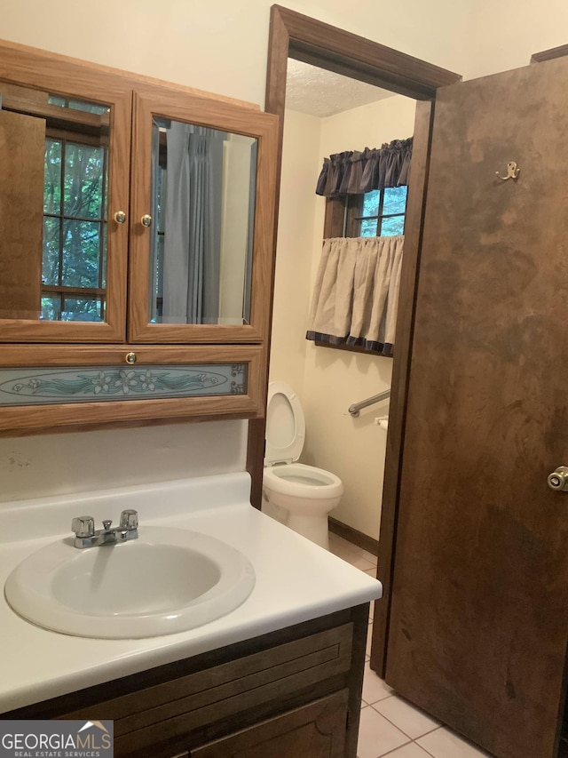 bathroom featuring tile patterned flooring, vanity, and toilet