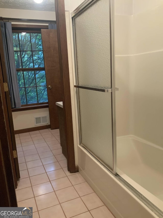 bathroom with tile patterned flooring and enclosed tub / shower combo