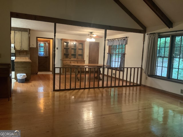 unfurnished living room featuring light wood-type flooring, lofted ceiling with beams, and ceiling fan