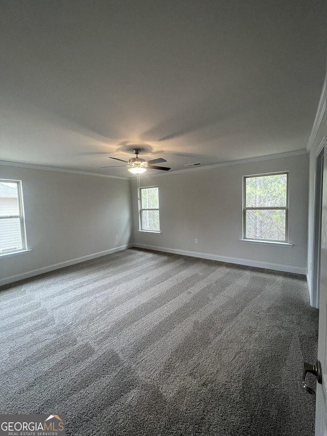 carpeted spare room with ceiling fan and ornamental molding