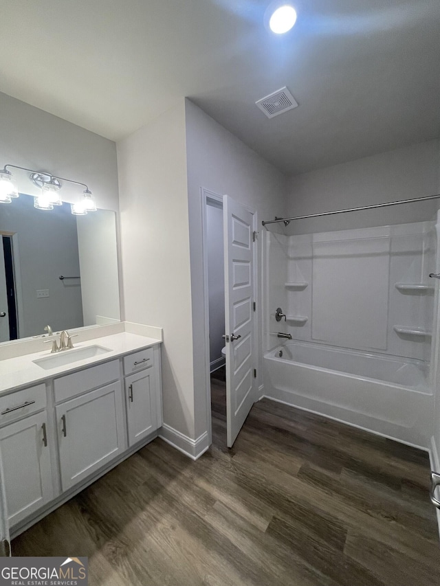 bathroom with hardwood / wood-style flooring, vanity, and shower / tub combination