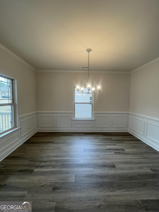 unfurnished dining area with a chandelier, dark hardwood / wood-style floors, and ornamental molding