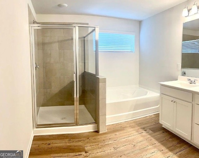 bathroom with independent shower and bath, vanity, and wood-type flooring