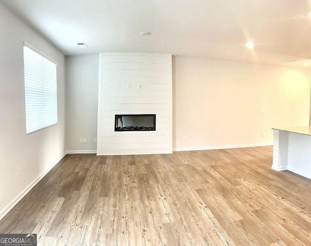 unfurnished living room with a fireplace and hardwood / wood-style floors