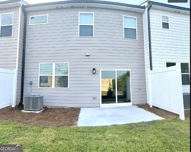 rear view of property with a yard, a patio area, and central air condition unit