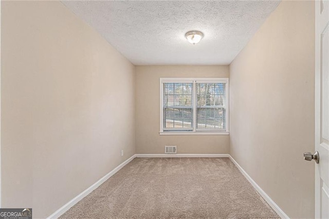 carpeted spare room with a textured ceiling