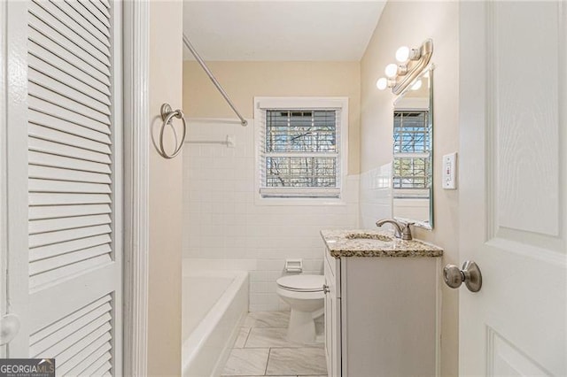 full bathroom with vanity, toilet, tile walls, and  shower combination