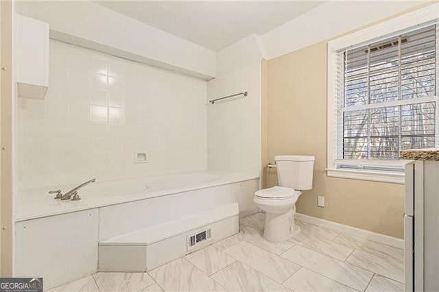 bathroom featuring a washtub and toilet