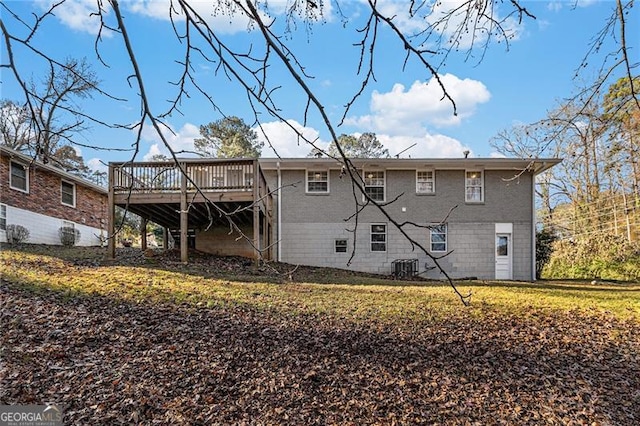 rear view of property with central air condition unit, a wooden deck, and a yard