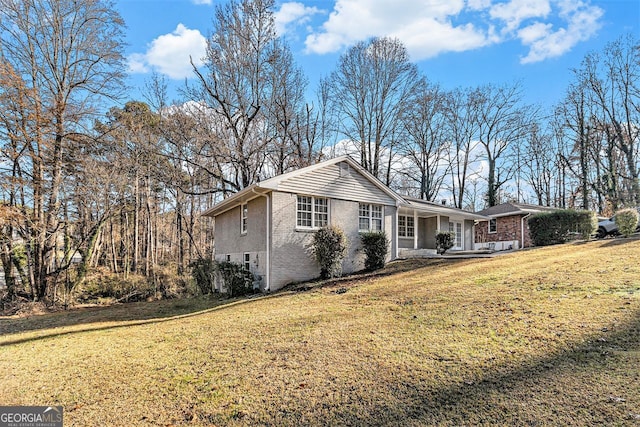 ranch-style home with covered porch and a front yard