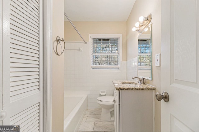 full bathroom featuring vanity, toilet, tile walls, and shower / washtub combination