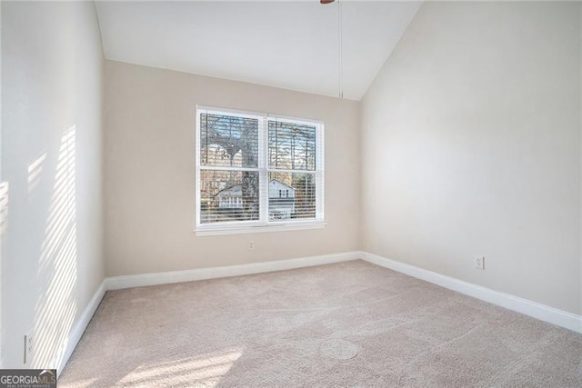 carpeted spare room with vaulted ceiling