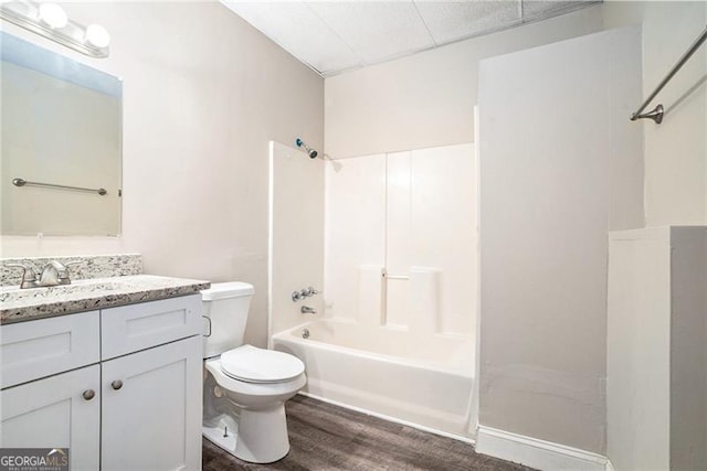 full bathroom featuring hardwood / wood-style flooring, vanity, toilet, and washtub / shower combination