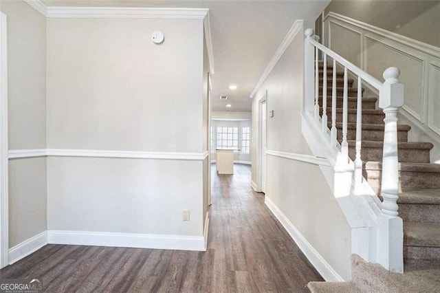 stairway featuring crown molding and hardwood / wood-style floors