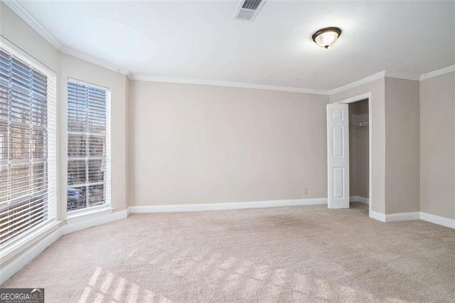 empty room with light colored carpet and crown molding