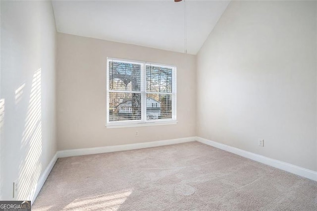 carpeted empty room with vaulted ceiling