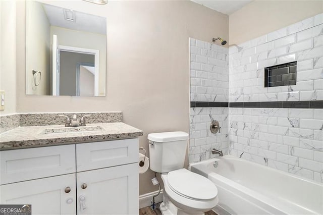 full bathroom with vanity, tiled shower / bath, and toilet