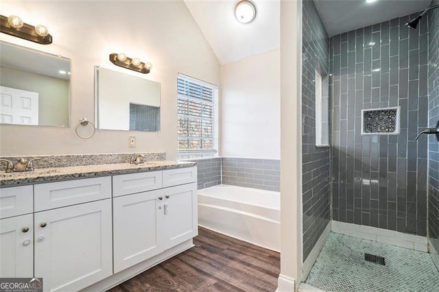 bathroom with vanity, wood-type flooring, vaulted ceiling, and shower with separate bathtub