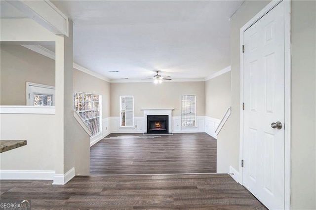 unfurnished living room featuring dark hardwood / wood-style floors, plenty of natural light, ornamental molding, and ceiling fan