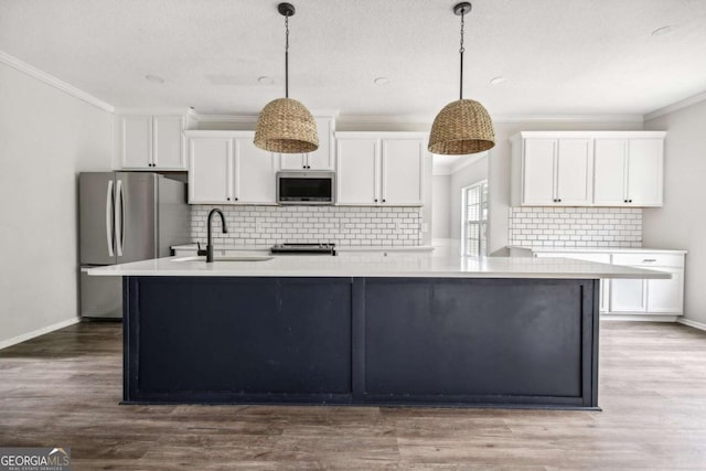 kitchen featuring appliances with stainless steel finishes, tasteful backsplash, white cabinetry, and hanging light fixtures