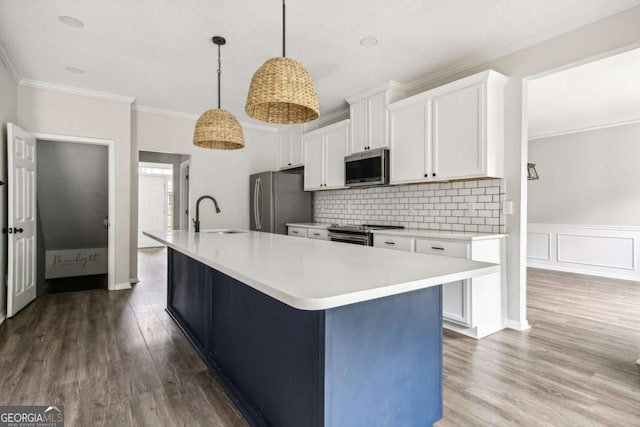 kitchen featuring white cabinetry, sink, stainless steel appliances, an island with sink, and pendant lighting