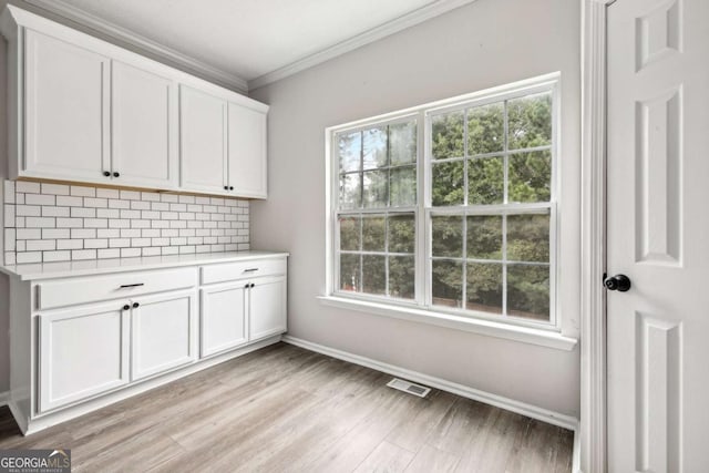 washroom with crown molding and light hardwood / wood-style floors